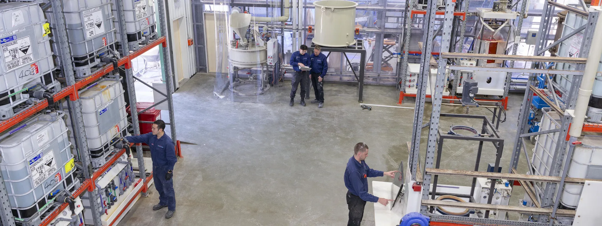 The hydrometallurgical floor at the PRiSM facility, with staff working between process rigs and storage tanks