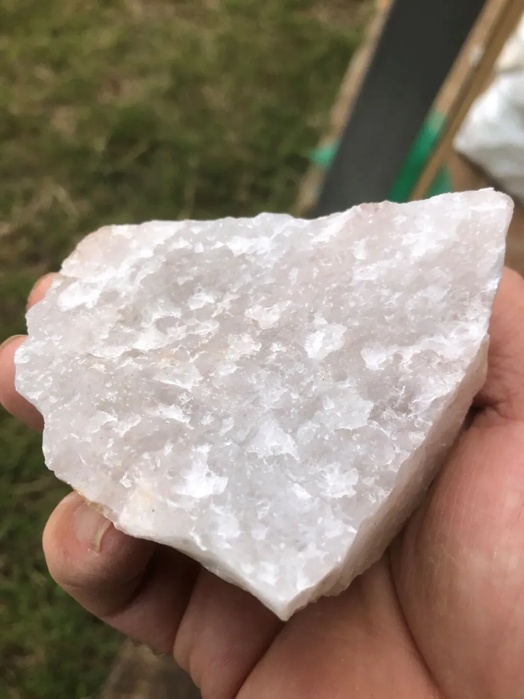 A hand holding a raw high-purity crystal sample